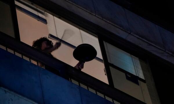  A woman in Rio de Janeiro beats a pan to protest against president Jair Bolsonaro